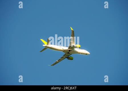 Weißes Passagierflugzeug, das am Himmel fliegt, erstaunliche Wolken im Hintergrund. Stockfoto