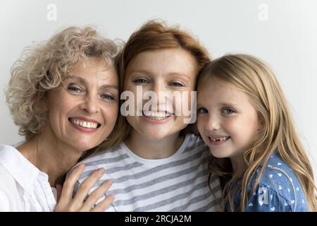 Fröhliches kleines Mädchen, hübsche mutter und Oma stehen sich nahe Stockfoto