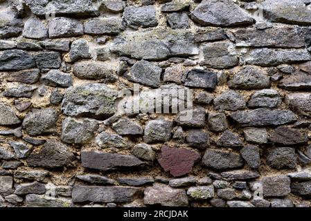 Hintergrund. Alte mittelalterliche Felsen, Steine. Muster. Vollformatfoto der Steinwand. Stockfoto