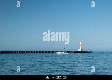 Ein Boot kommt an einem Läufer an einem Pier in Nord-Michigan vorbei Stockfoto