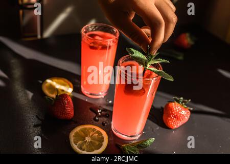 Erdbeer-Sangria. Eine köstliche Mischung aus Rotwein, frischen Erdbeeren und Zitrusfrüchten, serviert in einem Glas mit Eiswürfeln. Die lebendigen Farben Stockfoto