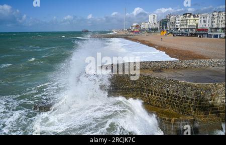 Brighton UK 15. Juli 2023 - Besucher werden nass, wenn sie sehen, wie riesige Wellen am Brighton Beach und am Ufer des Piers krachen, als ungewöhnlich starker Wind für Juli Batter Teile des Vereinigten Königreichs : Credit Simon Dack / Alamy Live News Stockfoto