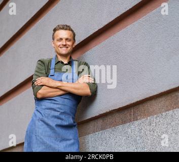 Kellner oder Servicemann an einer Restaurantwand. Mit einem professionellen Verhalten strahlt der einzelne Vertrauen aus und verkörpert die Grundwerte der Gastfreundschaft und des Kundenservice. . Hochwertiges Foto Stockfoto