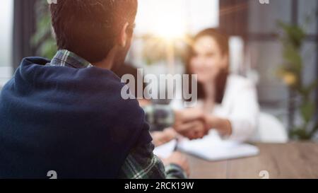Sitzt am Tisch mit Laptops. Junge Geschäftsleute in formeller Kleidung arbeiten im Büro Stockfoto