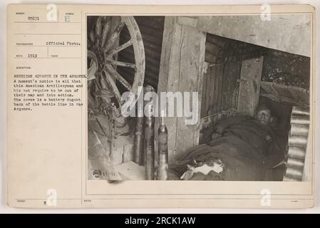 Ein amerikanischer Artillerist und seine Katze stehen bereit für Action in einer Batteriebehandlung während des amerikanischen Vormarsches in der Argonne. Dieses offizielle Foto, das mit der Nummer 23071 nummeriert und 1919 aufgenommen wurde, zeigt die Ruhe vor dem Sturm, während die Soldaten einen Moment auf Abruf bleiben. (50 Wörter) Stockfoto