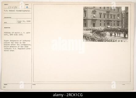 Mitglieder der 22. Infanterie USA Stammgäste präsentieren die Waffen auf der Beerdigung von Major J.P. Mitchell in New York City. Acht Sergeanten der Infanterie können gesehen werden, wie sie die Leiche nach den Zeremonien in den Leichenwagen legten. Dieses Foto wurde am 11. Juli 1918 aufgenommen. Stockfoto