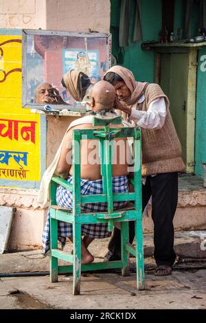 Friseur rasiert sich auf den Ghats von Varanasi, Indien Stockfoto