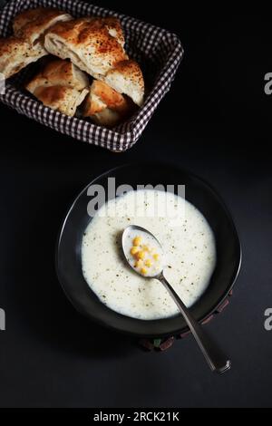 Von oben sehen Sie Ramadan Pita Brot und Suppe auf schwarzer Oberfläche Stockfoto