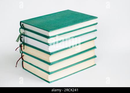 Grüne, feste Bücher auf weißer Oberfläche gestapelt mit Kopierbereich, Bildungskonzept Stockfoto