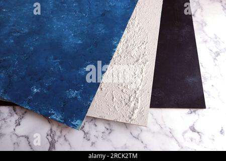 Blaue, graue und schwarze Faserplatten mittlerer Dichte auf Marmoroberfläche Stockfoto