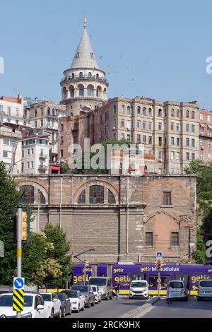 Straße im Karakoy Viertel von Istanbul mit einer Straßenbahn und dem Galatenturm dahinter. Möwen fliegen über dem Kopf. Türkei Stockfoto
