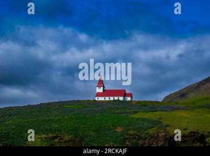 Red Roof Reyniskirkja Kirche auf dem Hügel in Vik Iceland Stockfoto