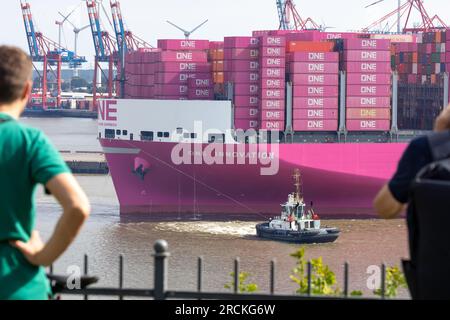 Hamburg, Deutschland. 15. Juli 2023. Das Containerschiff „One Innovation“ fährt zum ersten Mal in den Hamburger Hafen ein und wird auf die Elbe abgewandt. Mit einer Länge von 400 Metern und einer Breite von 61,40 Metern hat das rosafarbene Schiff ein Fassungsvermögen von etwa 24.000 Standardcontainern, wie die Schifffahrtsgesellschaft Ocean Network Express (ONE) angekündigt hat. Kredit: Bodo Marks/Bodo Marks/dpa/Alamy Live News Stockfoto