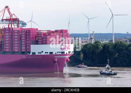 Hamburg, Deutschland. 15. Juli 2023. Das Containerschiff „One Innovation“ fährt zum ersten Mal in den Hamburger Hafen ein und wird auf die Elbe abgewandt. Mit einer Länge von 400 Metern und einer Breite von 61,40 Metern hat das rosafarbene Schiff ein Fassungsvermögen von 24.134 Standardcontainern, wie die Schifffahrtsgesellschaft Ocean Network Express (ONE) angekündigt hat. Kredit: Bodo Marks/Bodo Marks/dpa/Alamy Live News Stockfoto