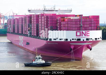 Hamburg, Deutschland. 15. Juli 2023. Das Containerschiff „One Innovation“ fährt zum ersten Mal in den Hamburger Hafen ein und wird auf die Elbe abgewandt. Mit einer Länge von 400 Metern und einer Breite von 61,40 Metern hat das rosafarbene Schiff ein Fassungsvermögen von etwa 24.000 Standardcontainern, wie die Schifffahrtsgesellschaft Ocean Network Express (ONE) angekündigt hat. Kredit: Bodo Marks/Bodo Marks/dpa/Alamy Live News Stockfoto