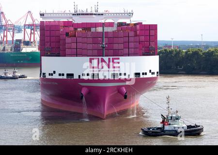 Hamburg, Deutschland. 15. Juli 2023. Das Containerschiff „One Innovation“ fährt zum ersten Mal in den Hamburger Hafen ein und wird auf die Elbe abgewandt. Mit einer Länge von 400 Metern und einer Breite von 61,40 Metern hat das rosafarbene Schiff ein Fassungsvermögen von etwa 24.000 Standardcontainern, wie die Schifffahrtsgesellschaft Ocean Network Express (ONE) angekündigt hat. Kredit: Bodo Marks/Bodo Marks/dpa/Alamy Live News Stockfoto