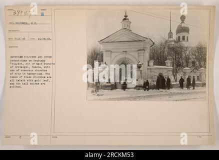 Amerikanische Soldaten und Fußgänger auf dem Troitsky Prospect, einer der Hauptstraßen in Archangel, Russland während des Ersten Weltkriegs. Das Foto, aufgenommen von CPL. Shotwell zeigt eine der vielen Kirchen der Stadt mit aufwändig gestalteten Blattgoldkuppeln und hohen vergoldeten Türmen. (111-SC-39147) Stockfoto