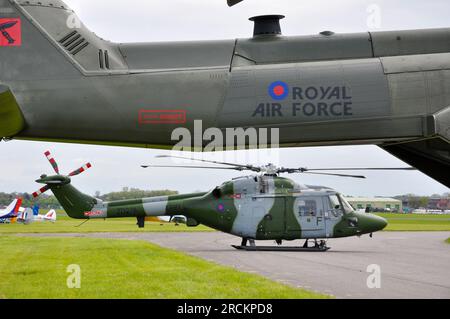 British Army Air Corps Westland WG-13 Lynx AH7 Hubschrauber, eingerahmt vom Schwanz eines Royal Air Force Merlin. Abingdon Flugschau Stockfoto