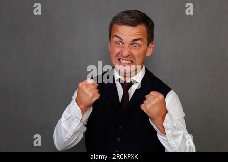 Porträt eines 30-35-jährigen Mannes, der seine Fäuste im Zorn zusammenbeißt. Stockfoto