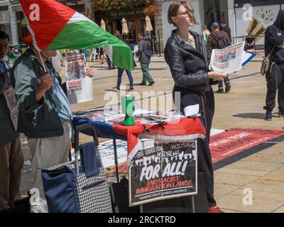 London, Großbritannien. 15. Juli 2023 Die Demonstranten in Hammersmith gegen das Gesetz über illegale Migration verteilen Flugblätter und sammeln Unterschriften, die besagen, dass es rassistisch ist, Sündenbock ist und Migranten und Asylbewerber kriminalisiert und ihnen ihre grundlegenden Menschenrechte vorenthalten. Die Regierung behauptet, sie sei mitfühlend, zeigt aber kein Mitgefühl und beabsichtigt, Migranten ungeachtet dessen einzusperren und nach Ruanda abzuschieben, ohne die Ursachen der Migration anzugehen. Peter Marshall/Alamy Live News Stockfoto