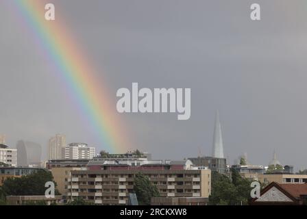 London, UK, 15. Juli 2023. Während Südeuropa von heißen Temperaturen heimgesucht wurde, gab das MET-Büro heute eine gelbe Wetterwarnung für London und den Südosten aus, aufgrund eines niedrigen Drucks. Es wurden starke Winde von bis zu 55 km/h erwartet, zusammen mit scharfen Schauern, die heute Abend zu diesem Regenbogen über der Stadt führten. Kredit : Monica Wells/Alamy Live News Stockfoto