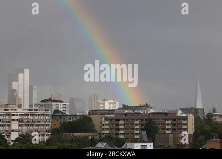 London, UK, 15. Juli 2023. Während Südeuropa von heißen Temperaturen heimgesucht wurde, gab das MET-Büro heute eine gelbe Wetterwarnung für London und den Südosten aus, aufgrund eines niedrigen Drucks. Es wurden starke Winde von bis zu 55 km/h erwartet, zusammen mit scharfen Schauern, die heute Abend zu diesem Regenbogen über der Stadt führten. Kredit : Monica Wells/Alamy Live News Stockfoto