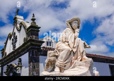 Statue des portugiesischen Prinzen Heinrich der Navigator, bekannt als Infante de Sagres, mit der Santa Catarina Kapelle im historischen Dorf Vila Franca do Campo auf der Insel Sao Miguel, Azoren, Portugal. Die Statue erinnert an 500 Jahre, seit die Portugiesen die Azoren entdeckt haben. Stockfoto