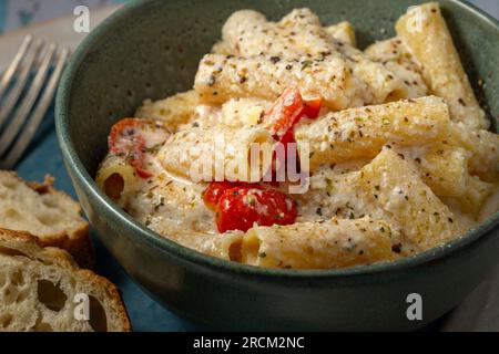 Rigatoni-Pasta mit Kirschtomaten und Ricotta-Sauce. Studioaufnahme. Stockfoto