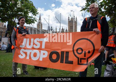 London, Großbritannien. 15. Juli 2023. Aktivisten werden während der Demonstration mit Bannern am Parlamentsplatz gesehen. Die 2022 gegründete Organisation Just Stop Oil. Sie beschreibt sich selbst als Koalition von Gruppen, die zusammenarbeiten, um die britische Regierung davon zu überzeugen, unverzüglich nicht mehr und mehr Geld in fossile Brennstoffe im Vereinigten Königreich zu investieren. Der langsame Marsch ist Teil ihres Wahlkampfes. Kredit: SOPA Images Limited/Alamy Live News Stockfoto