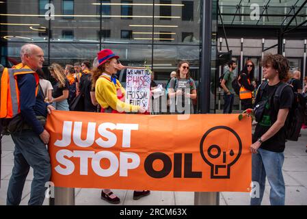 London, Großbritannien. 15. Juli 2023. Aktivisten werden während der Demonstration mit Bannern gesehen. Die 2022 gegründete Organisation Just Stop Oil. Sie beschreibt sich selbst als Koalition von Gruppen, die zusammenarbeiten, um die britische Regierung davon zu überzeugen, unverzüglich nicht mehr und mehr Geld in fossile Brennstoffe im Vereinigten Königreich zu investieren. Der langsame Marsch ist Teil ihres Wahlkampfes. Kredit: SOPA Images Limited/Alamy Live News Stockfoto