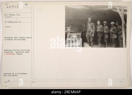 Amerikanische Soldaten in Frankreich erhalten Donuts von Arbeitern der Heilsarmee, bekannt als "Lassies". Die Donuts wurden hergestellt, um den Soldaten im Ersten Weltkrieg Komfort und einen Hauch von Zuhause zu bieten Dieses Foto wurde vom Zensor der amerikanischen Expeditionsstreitkräfte veröffentlicht. Das genaue Erfassungsdatum ist unbekannt. Stockfoto