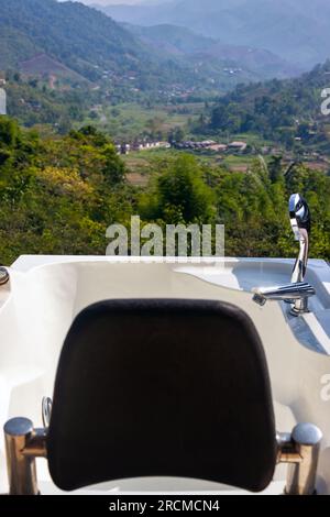 Eine Badewanne im Freien mit Blick auf eine Bergkette im Norden Thailands Stockfoto