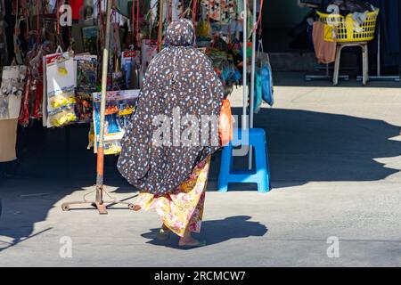Eine verschleierte Frau läuft mit Kiosken auf der Straße, Thailand Stockfoto