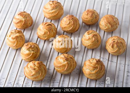 Frisch gebackene glutenfreie Haferflocken-Profiteroles auf einem Metallgitter. Stockfoto