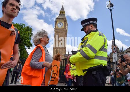 London, Großbritannien. 15. Juli 2023. Die Polizei verhängt Bedingungen für Sektion 12 und entfernt Just Stop Oil Aktivisten während des Protests auf dem Parliament Square von der Straße, während sie ihre täglichen langsamen Märsche fortsetzen und fordern, dass die Regierung keine neuen Lizenzen für fossile Brennstoffe mehr ausstellt. Kredit: SOPA Images Limited/Alamy Live News Stockfoto