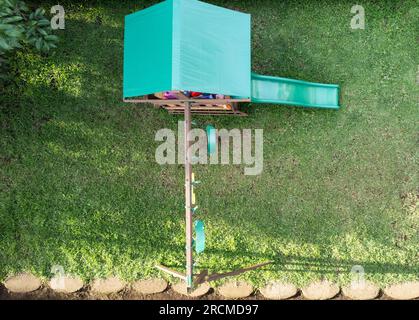 Kinderspielplatz mit Schaukeln und Rutschen auf grünem Gras über der Dröhne Stockfoto