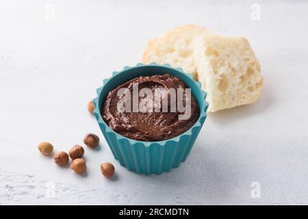 Vegane Schokoladenpaste mit Banane und Nüssen auf hellgrauem Hintergrund. Stockfoto