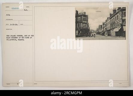 Soldaten marschieren die Island Street entlang, eine der Hauptstraßen in St. Quentin, Frankreich im Ersten Weltkrieg. Gebäude säumen die Straße mit Flaggen und Bannern. Die Stadt zeigt Anzeichen einer militärischen Besetzung, mit Soldaten und Zivilisten anwesend. Das Foto wurde von RECO am 5-12-19 aufgenommen. Stockfoto