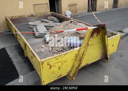 Müllcontainer aus Metall mit Bauabfällen gefüllt, Schutt in der Nähe einer Baustelle. In Europa Stockfoto