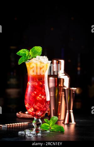 Aruba Ariba alkoholisches Cocktailgetränk mit Wodka, weißem Rum, Orangen-, Zitronen- und Ananassaft, Grenadine, dunkler Bartheke Hintergrund, Kopierbereich Stockfoto