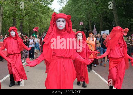 London, Großbritannien. 15. Juli 2023. Die roten Rebellen führen Klimaschutzaktivisten aus Fossil Free London, Just Stop Oil und anderen, die sich versammelten, um gegen das vorgeschlagene Öl- und Gasprojekt von Rosebank vorzugehen. Rosebank ist das größte noch nicht erschlossene Ölfeld im Vereinigten Königreich in der Nordsee und hat Verzögerungen bei der Genehmigung. Kredit: Elfte Stunde Fotografie/Alamy Live News Stockfoto
