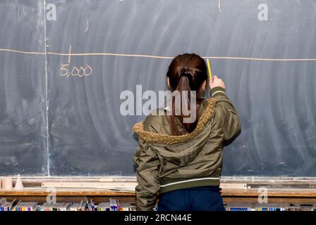 St. Paul, Minnesota. Community School of Excellence. Charterschule für die Hmong. Klasse 5. Brüche und Dezimalstellen. Ein Hmong-Student, der sich eine Wolle teilt Stockfoto