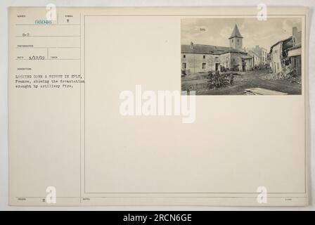 Straße in Eply, Frankreich, mit erheblichen Schäden durch Artilleriefeuer im Ersten Weltkrieg. Bäume werden von Zweigen befreit, Gebäude werden zerstört, und überall sind Trümmer verstreut. Die Verwüstung ist offensichtlich, da die Straße verlassen und still liegt. Stockfoto