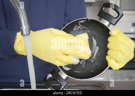 Männer waschen schmutzige Teller in der Küchenspüle, schließen Stockfoto
