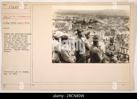 Eine Gruppe französischer und amerikanischer Soldaten stand auf einem Hügel mit Blick auf die Stadt Chateau Thierry, die zuvor von den Deutschen kontrolliert wurde. Dieser Ort markiert den erfolgreichen Stopp der deutschen Offensive und den Beginn der französisch-amerikanischen Gegenoffensive. Das Foto wurde am 28. Juli 1918 aufgenommen und am 13. August 1918 vom A. E. P. Censor herausgegeben. Stockfoto