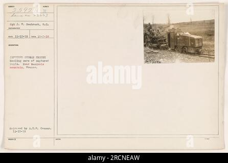 Sgt J.T. Seabrook steht neben einer gefangenen deutschen Lokomotive und transportiert Autos mit gefangenen Schienen nahe Vanquois Mountain, Frankreich. Das Foto wurde am 2. Oktober 1918 aufgenommen und von A.E.P. veröffentlicht Zensor am 15. November 1918. Die Nummer des Fotografen für dieses Bild ist 25921, und es wird als 23663 lahm beschrieben. Stockfoto