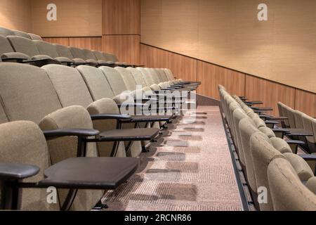 Großer Auditorium mit leeren Stühlen und kleinen Beistelltischen in einem Konferenzzentrum Stockfoto