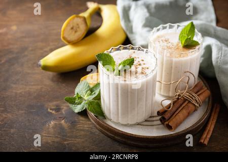 Entgiftungsmenü. Bananen-Smoothie mit Zimt in Trinkglas auf Holzhintergrund. Speicherplatz kopieren. Stockfoto