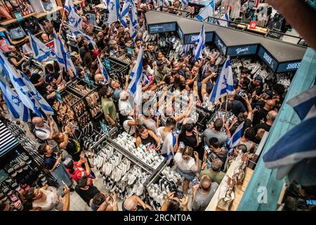 Tel Aviv, Israel. 11. Juli 2023. Israelische Demonstranten folgen Polizeibeamten in einen Laden, während sie Aviv Geffen, einen israelischen Rockstar während einer Demonstration gegen die Justizreform, festnehmen. Kredit: SOPA Images Limited/Alamy Live News Stockfoto