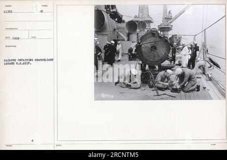 Matrosen reparieren Suchscheinwerfer an Bord eines U.S.-Schiffs. Das Foto wurde in den 1910er Jahren aufgenommen und mit der Nummer 11753 ausgestellt. Es wurde 1919 von einem Fotografen namens RECO aufgenommen. Dieses Bild ist Teil einer Sammlung mit dem Titel „Fotos der amerikanischen Militäraktivitäten während des Ersten Weltkriegs“. Stockfoto